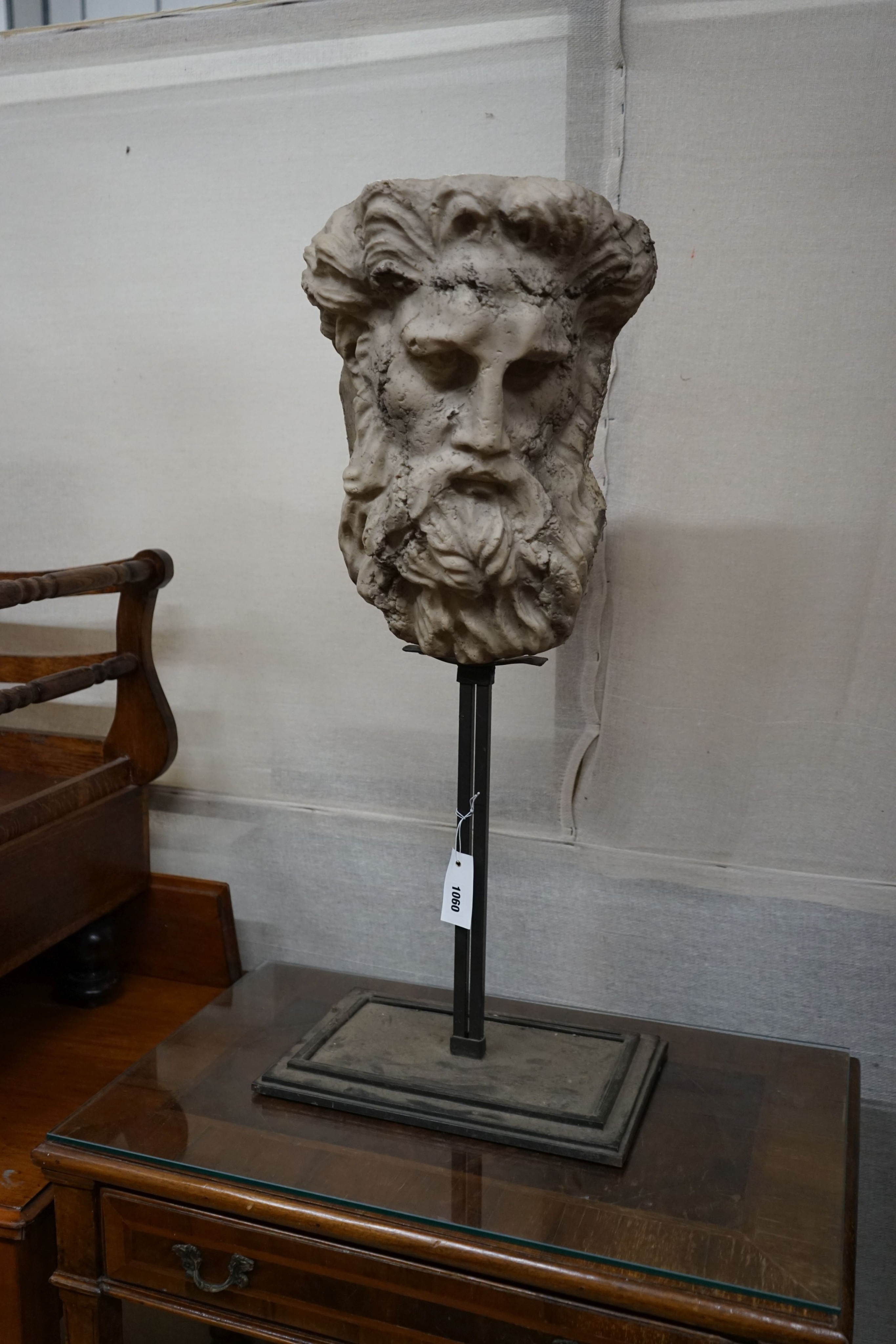 After the Antique. A composition classical mask on stand, height 79cm